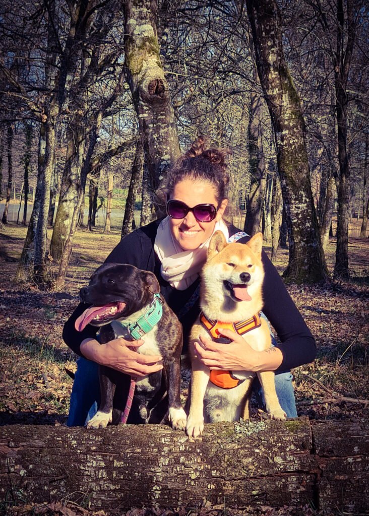Femme avec deux chiens, un staffie bringé et un shiba roux